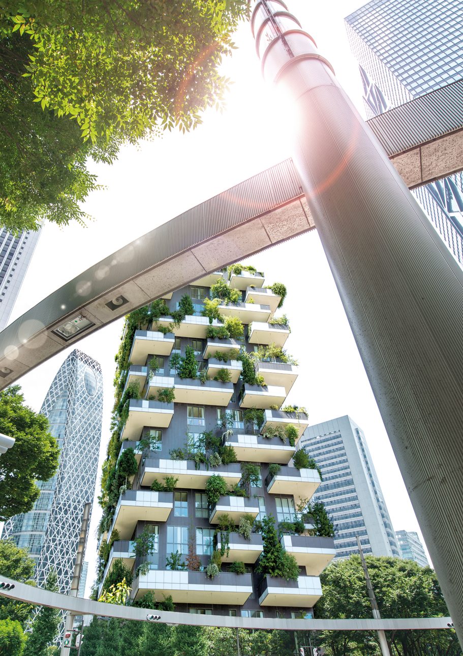 Moderne, begrünte Wohnanlage mit Balkonen, umgeben von Hochhäusern und Sonnenschein.