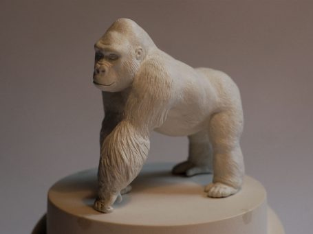 Skulptur eines Gorillas auf einem runden Sockel, detailliert und realistisch.