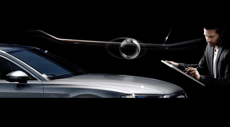 Mann in Anzug neben einem silbernen Auto mit einem schwebenden Drone-ähnlichen Gerät.