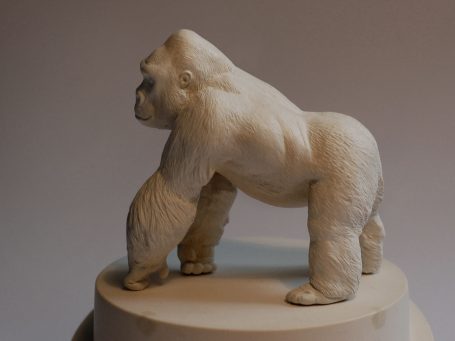 Skulptur eines Gorillas in einer neutralen Pose auf einem Sockel.