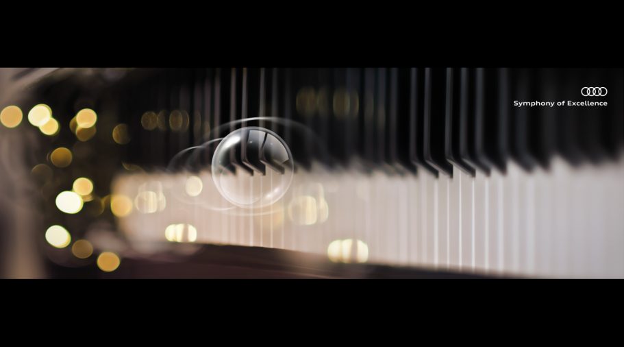 Nahaufnahme von Pianotasten mit unscharfen Lichtern im Hintergrund.